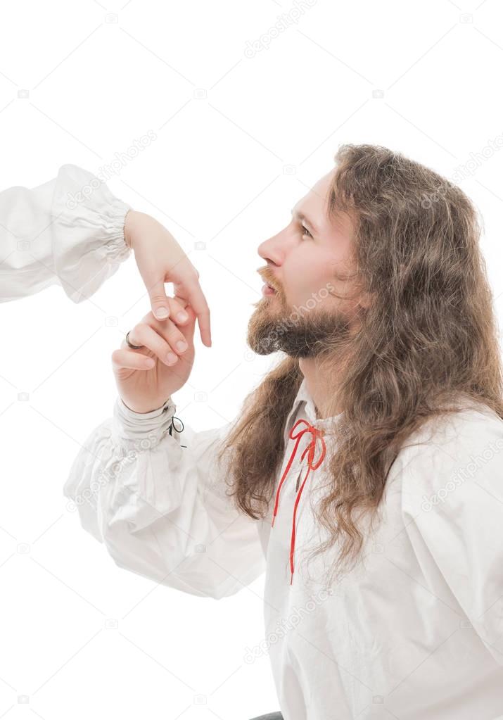 Handsome man in medieval shirt kissing hand of woman