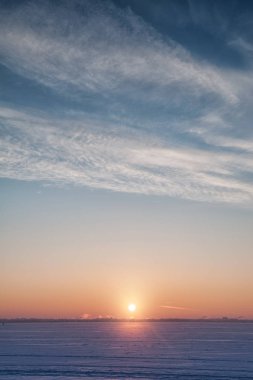 Soğuk kış manzarası kar, gökyüzü ve güneş ufukta
