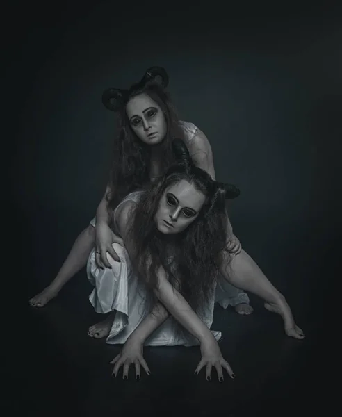 Два ужасных призрака с рогами в темноте — стоковое фото