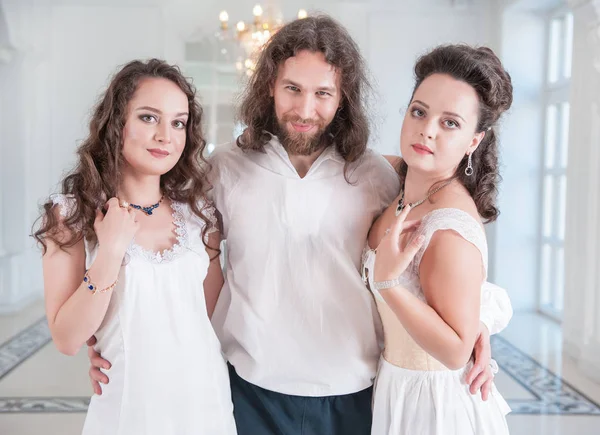 Homme en costume médiéval et deux belles femmes à l'ancienne — Photo