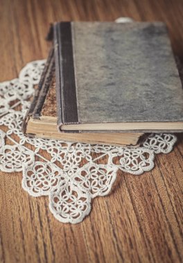 Eski kitaplar ve ahşap üzerine dantel masa örtüsü ile natürmort