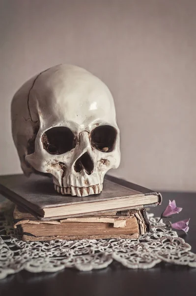 stock image Still life with human skull and old vintage book on wood