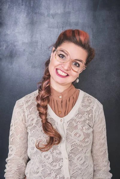 Lachende vrouw met gekke grimas op schoolbord achtergrond — Stockfoto
