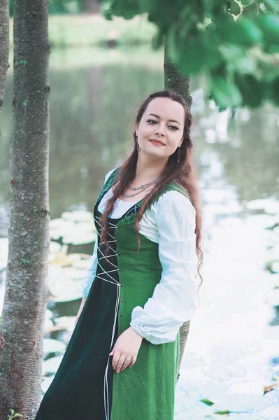 Mulher bonita em vestido medieval verde perto do rio — Fotografia de Stock