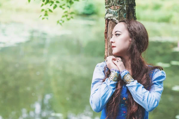 Mooie vrouw in blauwe middeleeuwse jurk in de buurt van rivier — Stockfoto