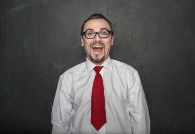 Portrait of funny handsome man laughing on chalkboard background