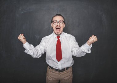 Successful happy man with raising arms on chalkboard background