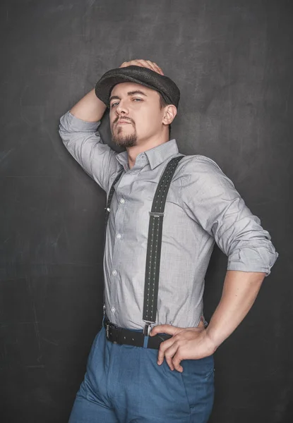 Schöner Mann im Retro-Stil mit Mütze auf Tafel-Hintergrund — Stockfoto