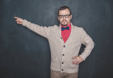 Öfkeli öğretmen tahtadaki arka plana işaret ediyor