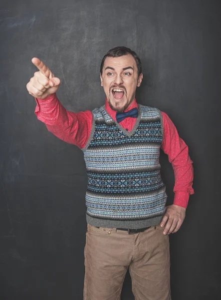 Boos gillen leraar wijzen op schoolbord achtergrond — Stockfoto