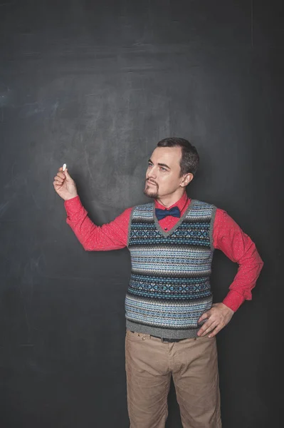 Zamyšlený učitel s křídou na tabuli — Stock fotografie