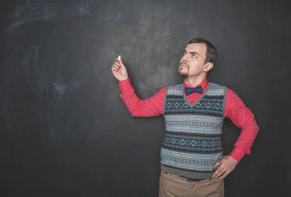 Tankeväckande lärare med krita tittar upp på Blackboard — Stockfoto