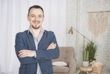 Yakışıklı, mutlu adam gülümsemesi evde duruyor.