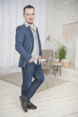 Yakışıklı, mutlu adam gülümsemesi evde duruyor.