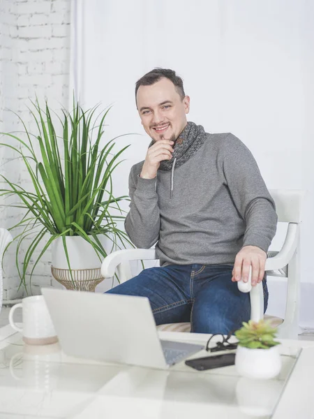 Счастливый человек, работающий на ноутбуке с чашкой кофе дома — стоковое фото