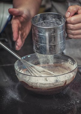 Lav keki için krema cam kasede ellerle yemek pişirmek ve un serpmek.