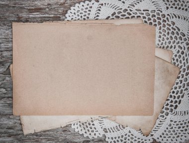 Köhne ahşap tahtanın üzerinde dantelli eski bir kağıt çarşaf.