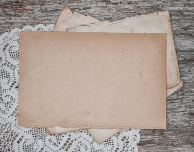 Köhne ahşap tahtanın üzerinde dantelli eski bir kağıt çarşaf.