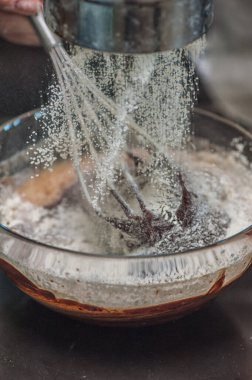 Elleri cam kasede pişirilmiş ve un serpiştirilmiş hamur tatlısı