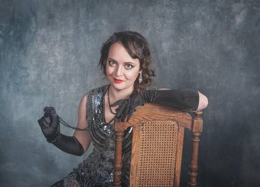 Mavi arka planda geçmişe dönük zarif bir kadının portresi.