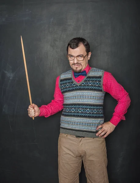 Angry teacher in retro style with pointer on blackboard background