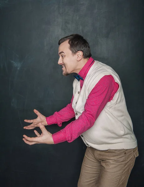 Αστείος Δάσκαλος Επιχειρηματίας Κρατώντας Κάτι Στα Χέρια Του Μαυροπίνακα Φόντο — Φωτογραφία Αρχείου