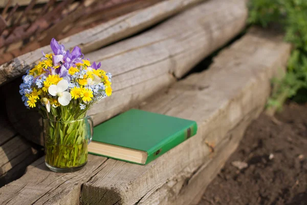 still-life book flowers on a wooden bench