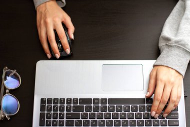 Gümüş klavyede kadın elleri. Evde dizüstü bilgisayarcı kadınla çalışmak.