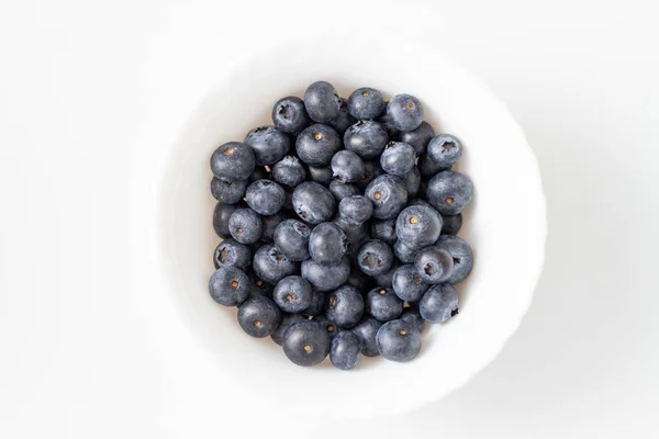 Fresh blueberries in a bowl isolated on white background. Top view — Stock Photo, Image