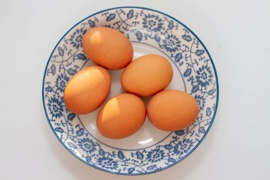 Beyaz arka planda kaynamış kahverengi yumurtalı kase.