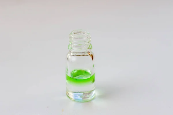 Зеленое ароматное масло для ароматерапии в стеклянной бутылке на белом фоне — стоковое фото