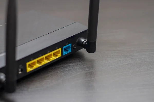 Czarny bezprzewodowy router wifi złącza sieciowe na czarnym stole — Zdjęcie stockowe