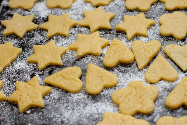 a cookies made from dough in the shape of hearts and stars on a baking sheet with flour