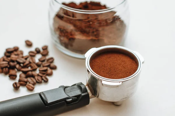 coffee horn with natural ground coffee and ground coffee in a glass jar, close up