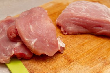 Kesme tahtasında doğranmış taze et parçaları.