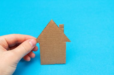 Mavi arka planda bir mukavva ev tabelası.