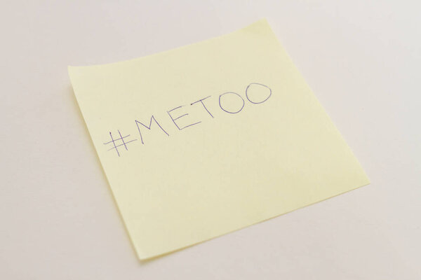 Yellow sticker of paper with hand drawn text Me Too on white background