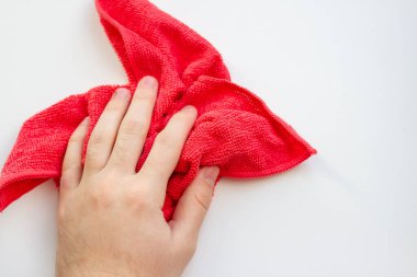 Beyaz arka planda kırmızı mikrofiber kumaşlı bir el. Ev temizliği