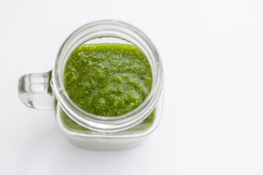 Yeşil meyve suyu ve çiğ sebzeli cam kavanoz.