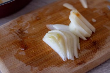 Tahta kesme tahtasında dilimlenmiş armutlar..