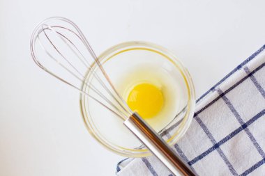 Cam kasede yumurta sarısı ve beyaz arka planda mutfak havlusu..