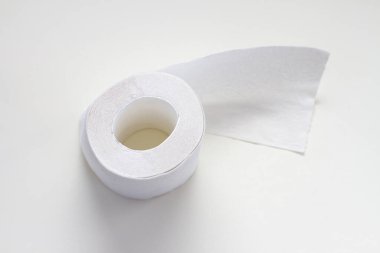 Açık gri arka planda beyaz tuvalet kağıdı rulosu. Üst görünüm