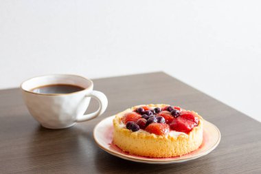 Çilekli kek ve masada bir fincan kahve. Seçici odak.