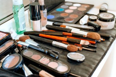 Makyaj seti, makyaj fırçaları ve siyah arka planda maskara. Makyaj için dekoratif kozmetik ürünler, kozmetik fırçalı paletler.