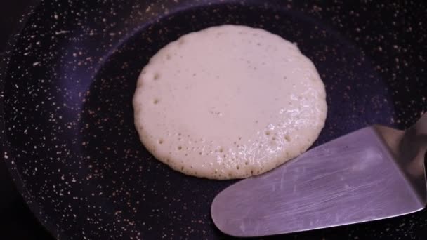 O processo de cozinhar panquecas caseiras. Despejar massa de panqueca na panela. Mãos fritando panquecas na frigideira — Vídeo de Stock