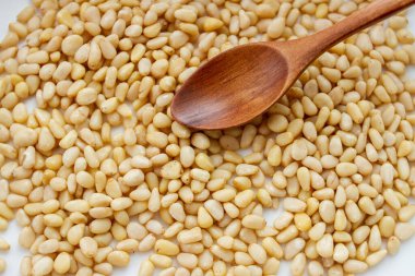 Tahta kaşıkta soyulmuş çam fıstığı. Çam fıstıklarının arka planı