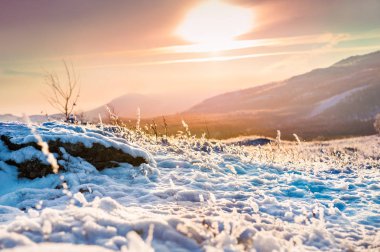Karla kaplı dağlar gün batımında.