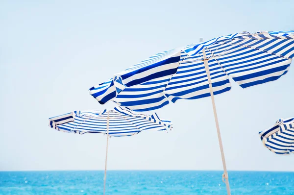 Beach umbrellas, blue sea and sky in background. — Stock Photo, Image