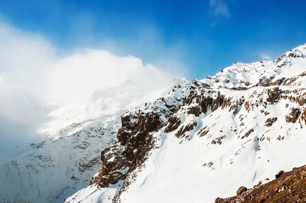 Montañas cubiertas de nieve y cielo azul . — Foto de Stock