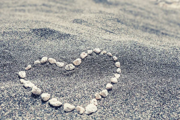 Steine in Herzform im Sand — Stockfoto